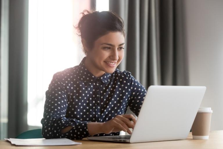 Young indian woman sitting at a laptop